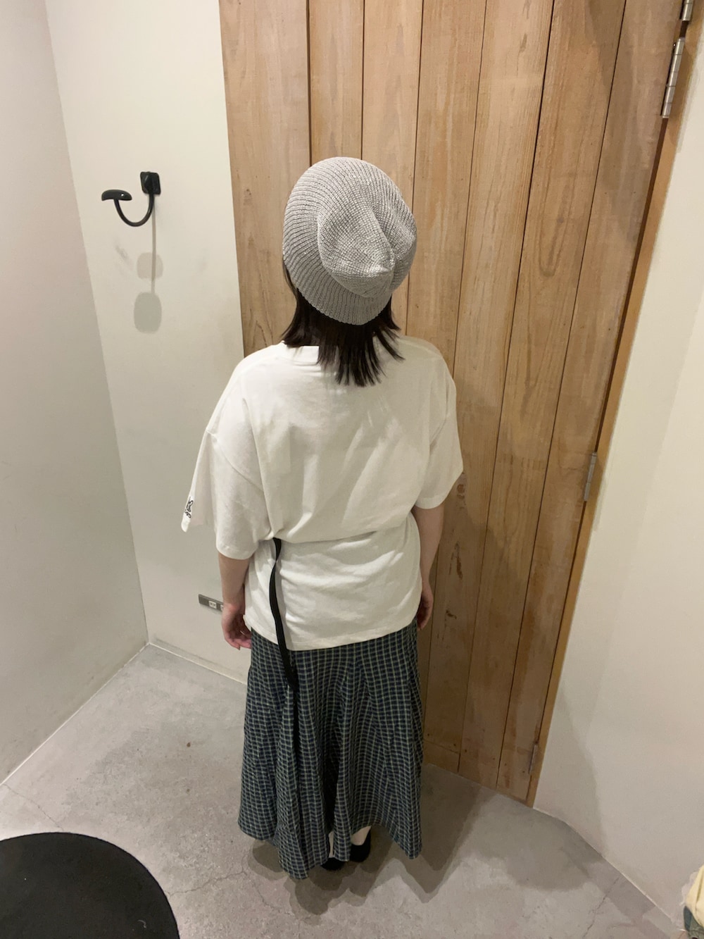 ホワイト系のTシャツ/カットソー、ブラック系のスカート、ブラック系のトートバッグを着用したレディースの春コーディネートの3枚目の写真