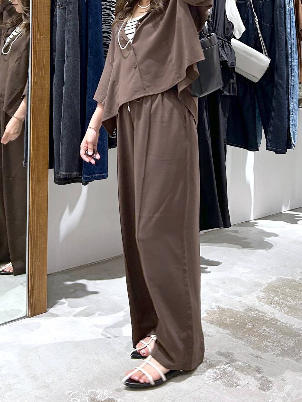 ホワイト系のタンクトップ、ホワイト系のサンダル、ブラウン系のシャツ/ブラウスを着用したレディースの夏コーディネートの2枚目の写真