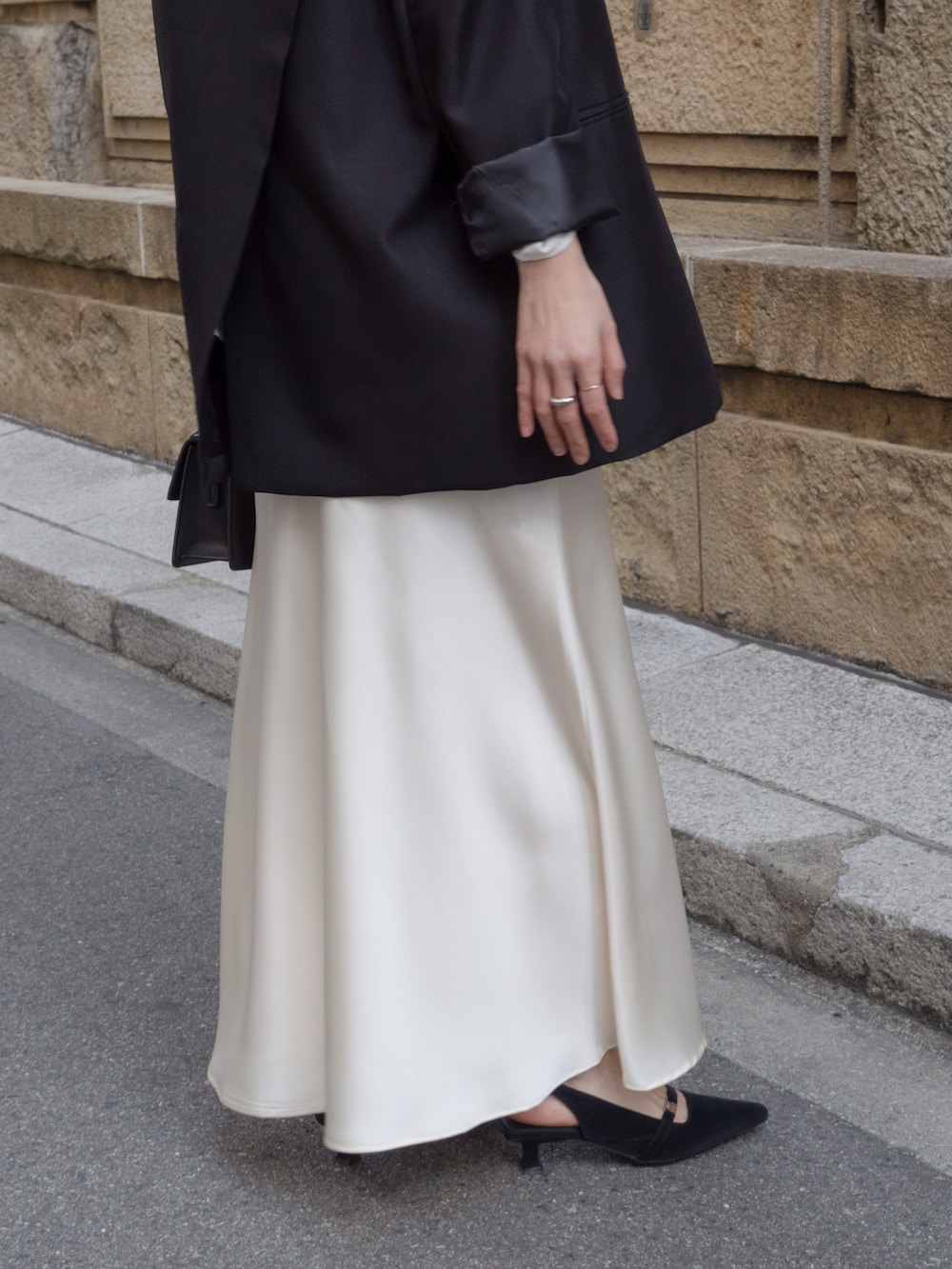 ブラック系のテーラードジャケット、ホワイト系のスカート、ブラック系のパンプスを着用したレディースの冬コーディネートの4枚目の写真