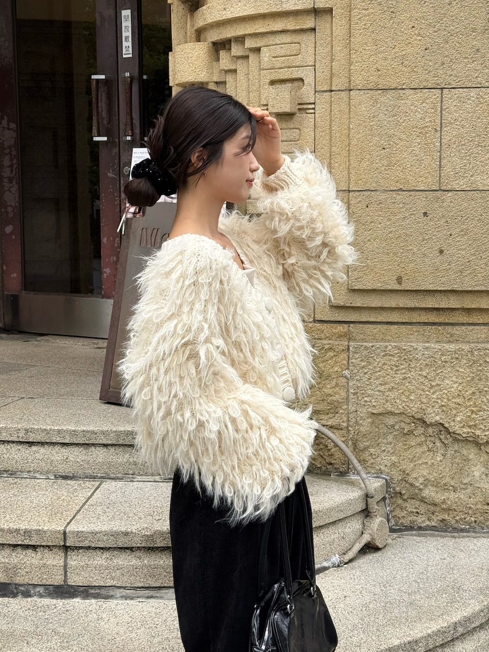 ホワイト系のカーディガン/ボレロ、ブラック系のショルダーバッグ、ブラック系のバレエシューズを着用したレディースの秋コーディネートの4枚目の写真