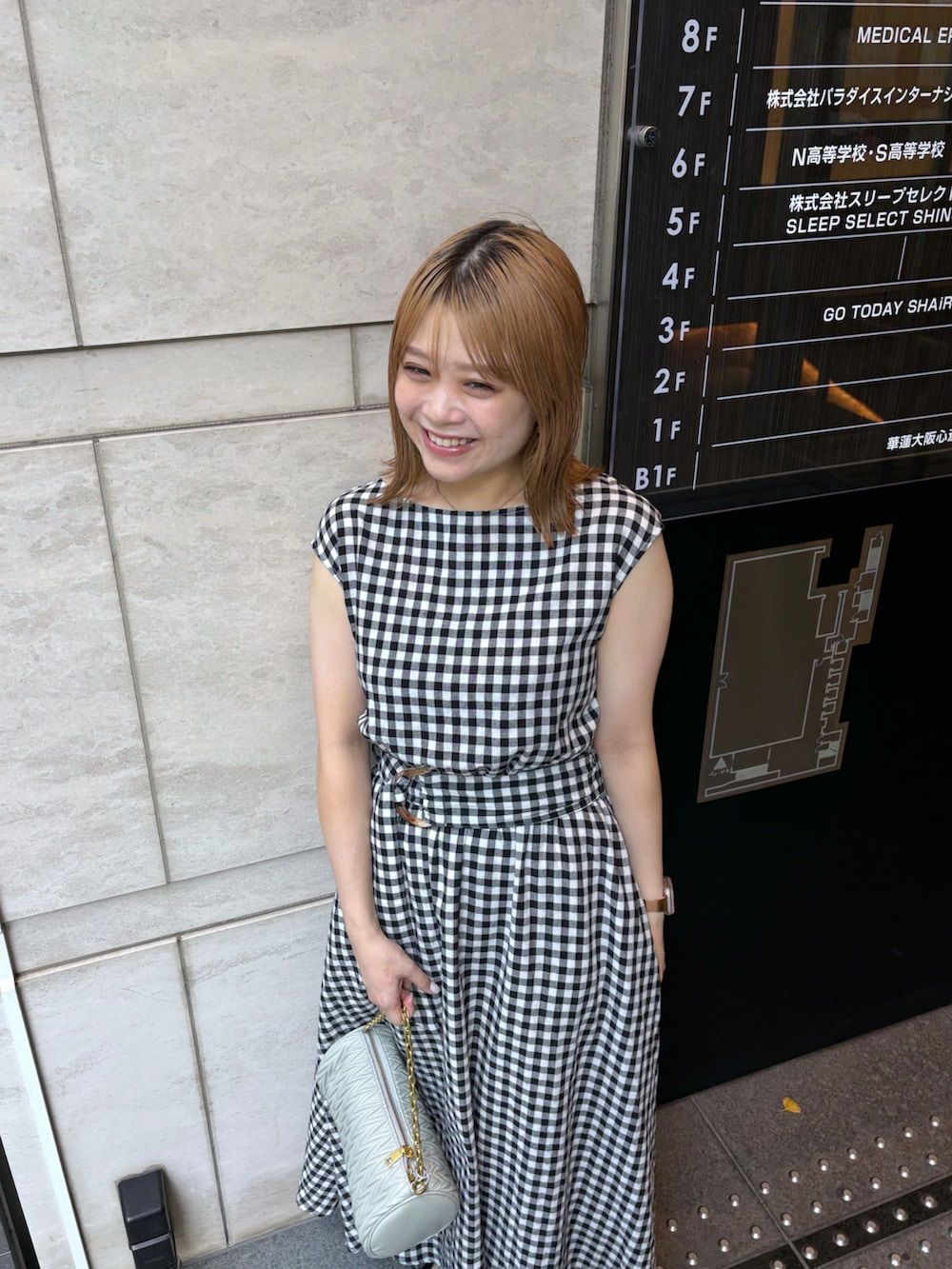 グリーン系のショルダーバッグ、その他のワンピースを着用したレディースの夏コーディネートの2枚目の写真