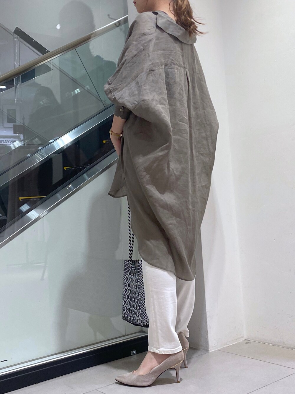 ホワイト系のトートバッグ、グリーン系のシャツ/ブラウス、ホワイト系のデニムパンツを着用したレディースの夏コーディネートの2枚目の写真