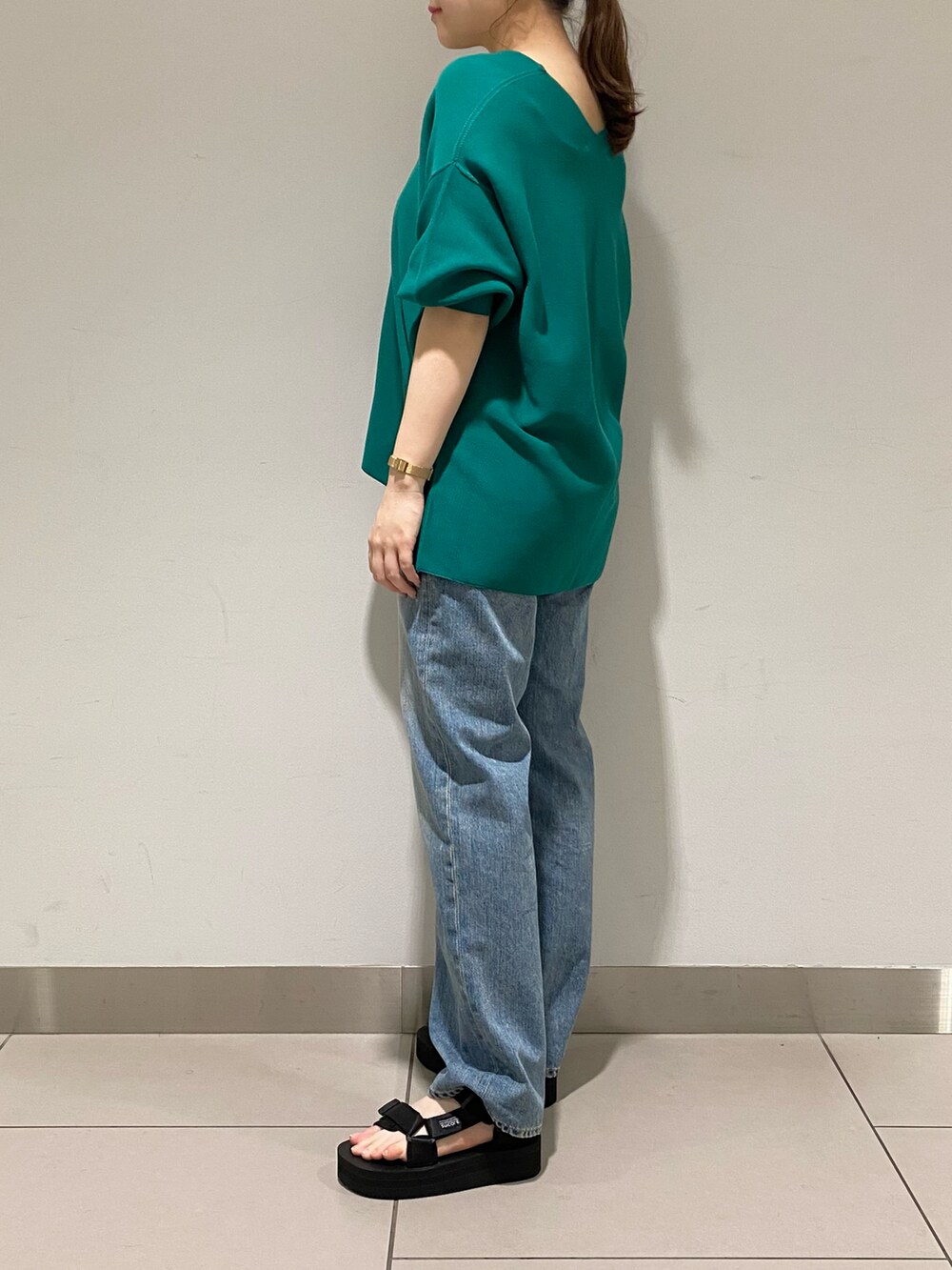 ブルー系のデニムパンツ、ブラック系のニット/セーター、ブラック系のその他シューズを着用したレディースの春コーディネートの2枚目の写真