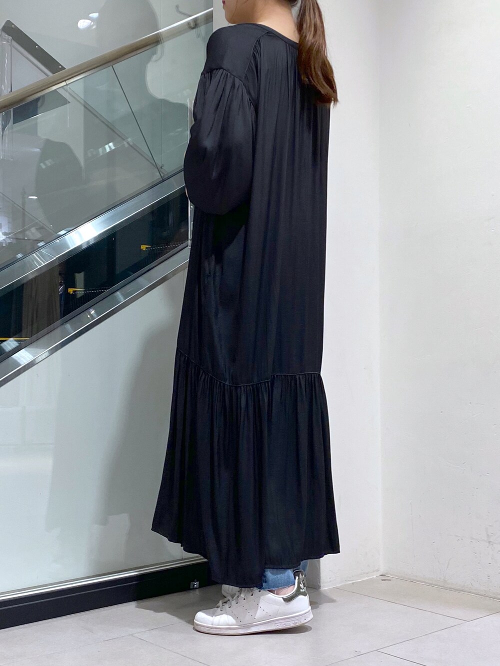 ホワイト系のスニーカー、ブルー系のデニムパンツ、ホワイト系のショルダーバッグを着用したレディースの秋コーディネートの2枚目の写真