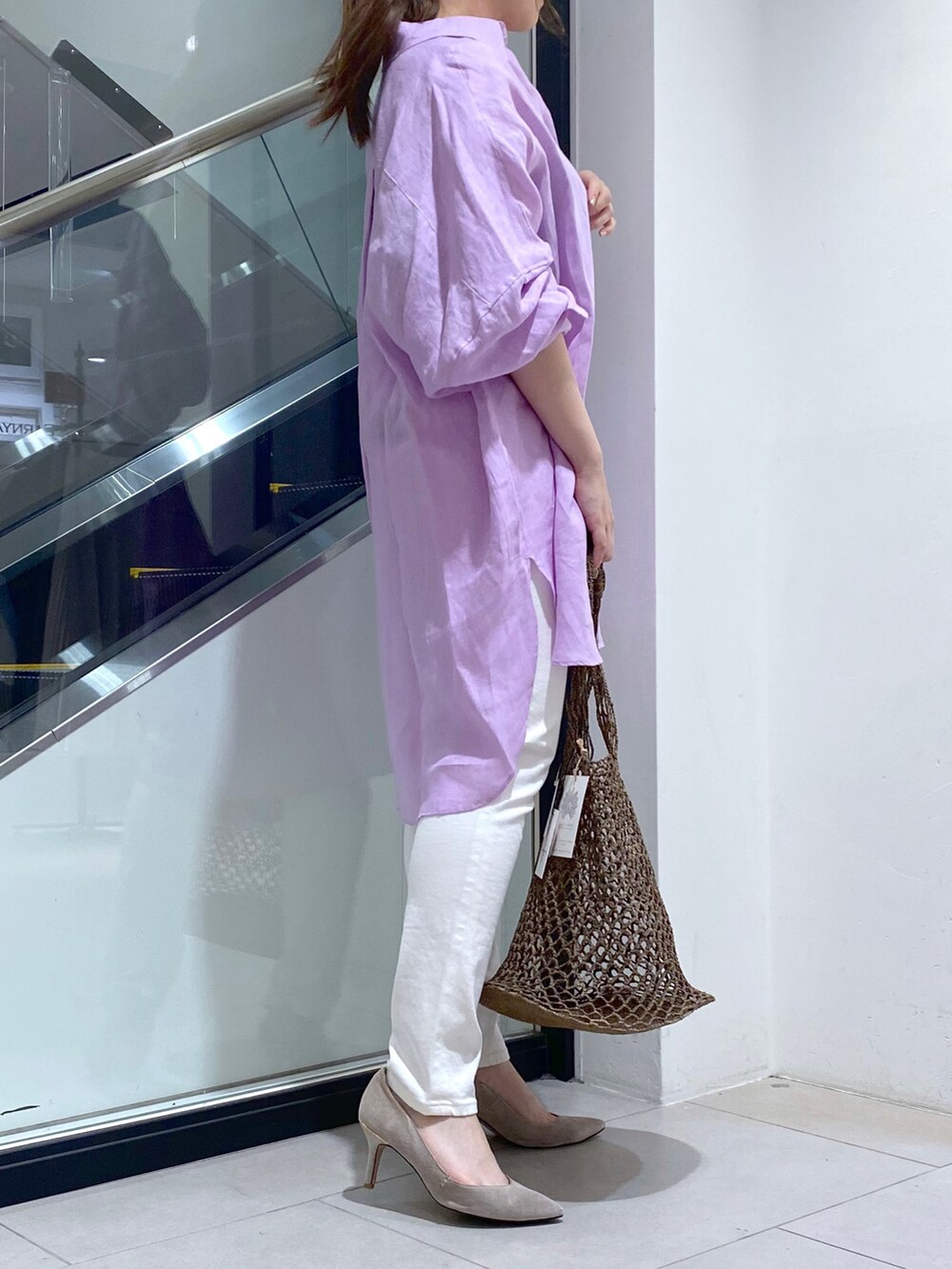 ベージュ系のショルダーバッグ、ホワイト系のシャツ/ブラウス、ホワイト系のデニムパンツを着用したレディースの夏コーディネートの2枚目の写真