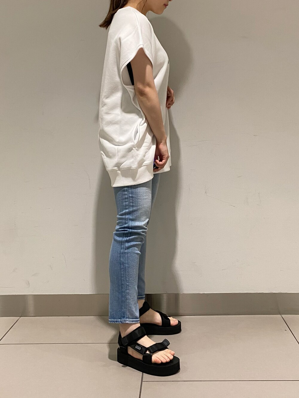 ホワイト系のTシャツ/カットソー、ブルー系のデニムパンツ、ブラック系のその他シューズを着用したレディースの春コーディネートの2枚目の写真