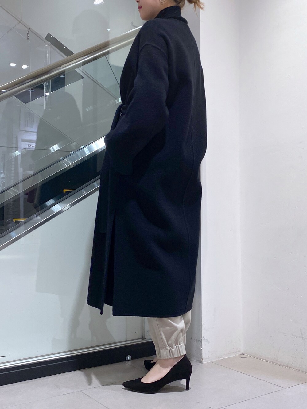 ホワイト系のその他パンツ、ブラック系のノーカラーコート、ブラック系のニット/セーターを着用したレディースの秋コーディネートの3枚目の写真