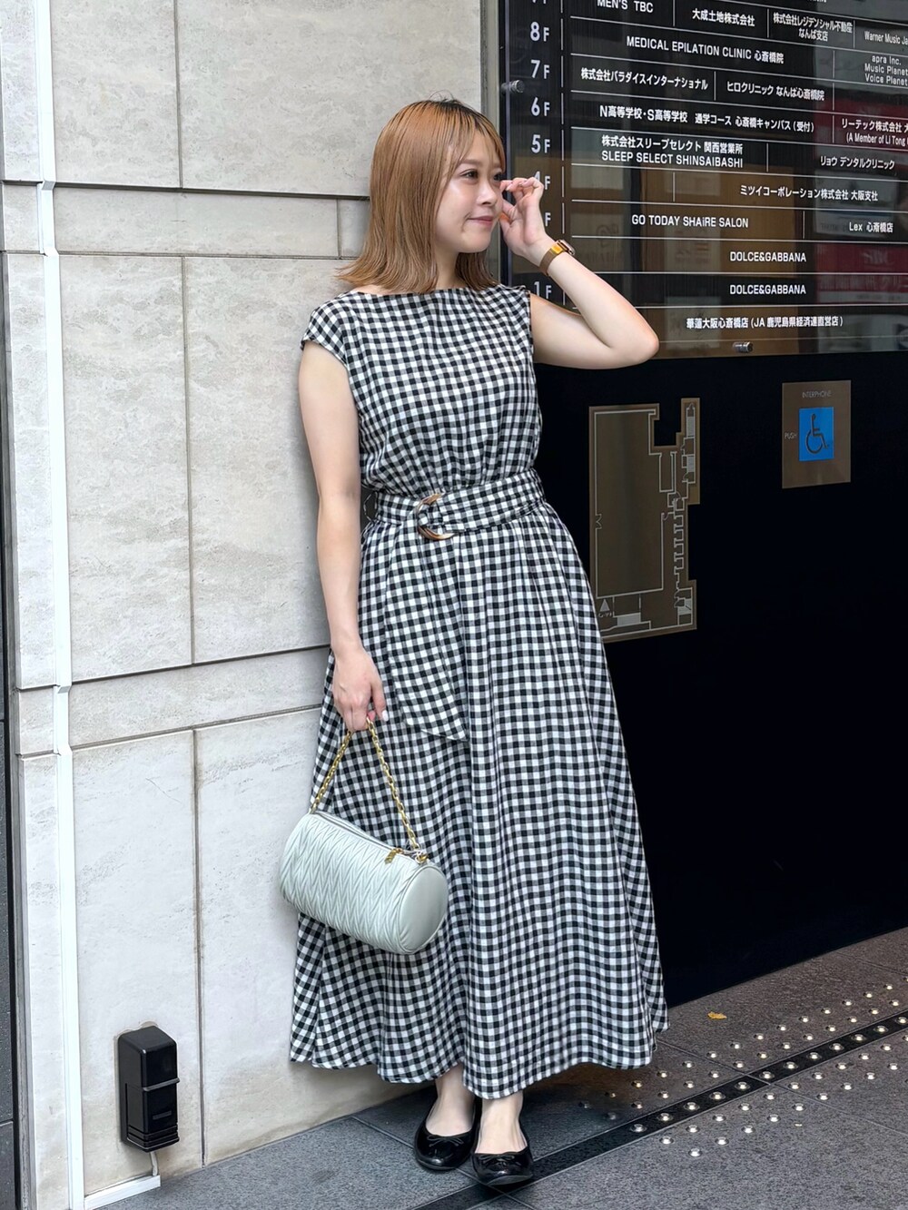 グリーン系のショルダーバッグ、その他のワンピースを着用したレディースの夏コーディネートの3枚目の写真