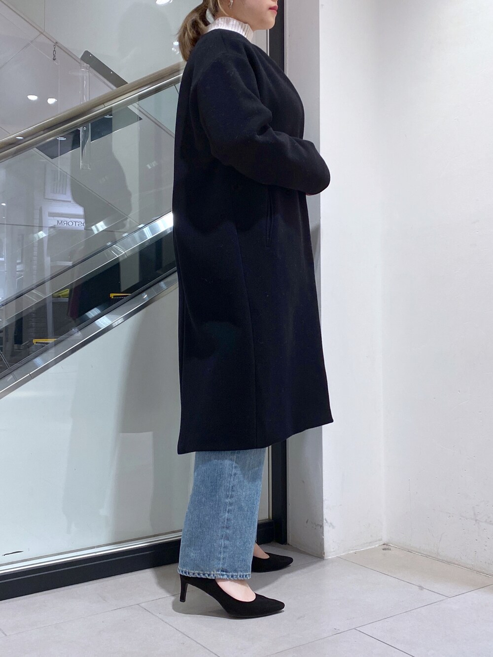 ブルー系のデニムパンツ、ホワイト系のニット/セーター、ブラック系のその他アウターを着用したレディースの冬コーディネートの2枚目の写真