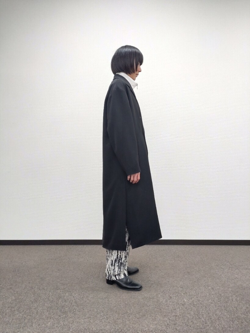 ブラック系のチェスターコート、ホワイト系のTシャツ/カットソー、グレー系のその他パンツを着用したメンズの秋コーディネートの4枚目の写真