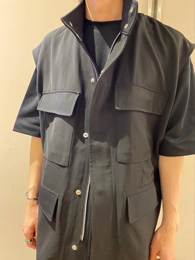 ブラック系のベスト、ホワイト系のその他パンツ、ブラック系のサンダルを着用したメンズの春コーディネートの4枚目の写真