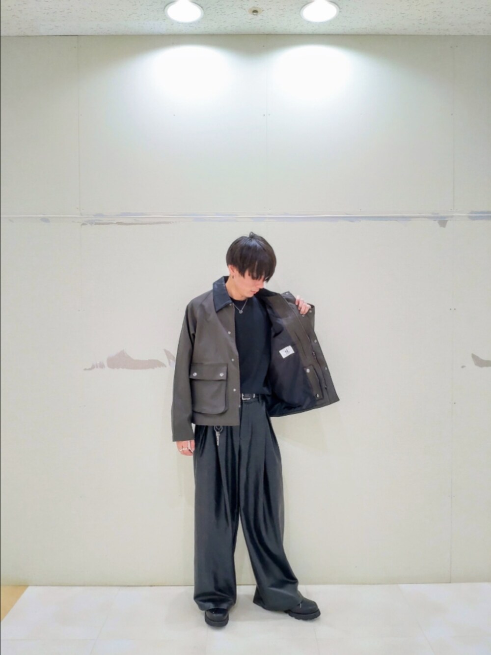 グリーン系のブルゾン、ブラック系のその他パンツ、ブラック系のドレスシューズを着用したメンズの秋コーディネートの3枚目の写真