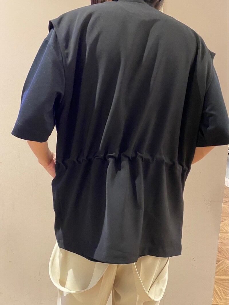 ブラック系のベスト、ホワイト系のその他パンツ、ブラック系のサンダルを着用したメンズの春コーディネートの3枚目の写真