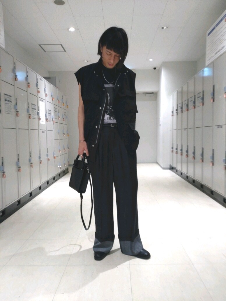 ブラック系のデニムパンツ、ブラック系のブーツ、ブラック系のタンクトップを着用したメンズの春コーディネートの3枚目の写真