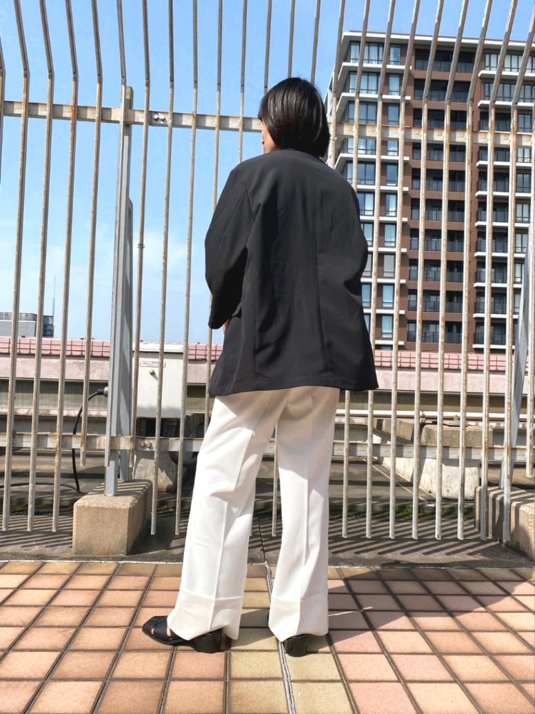 ブラック系のテーラードジャケット、ホワイト系のその他パンツ、ブラック系のサンダルを着用したメンズの春コーディネートの2枚目の写真