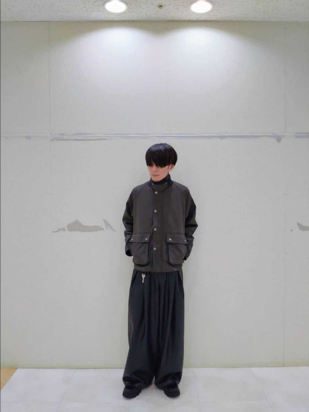 グリーン系のブルゾン、ブラック系のその他パンツ、ブラック系のドレスシューズを着用したメンズの秋コーディネートの6枚目の写真