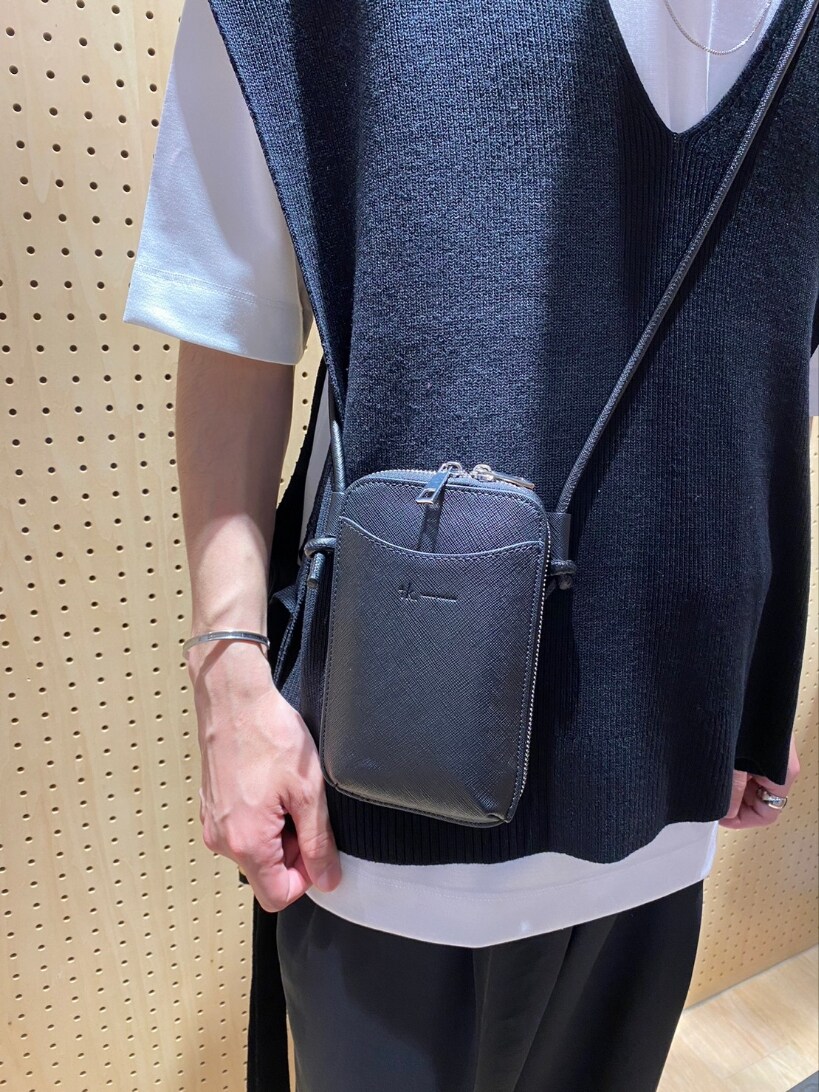 ブラック系のベスト、ホワイト系のTシャツ/カットソー、ブラック系のショルダーバッグを着用したメンズの春コーディネートの3枚目の写真