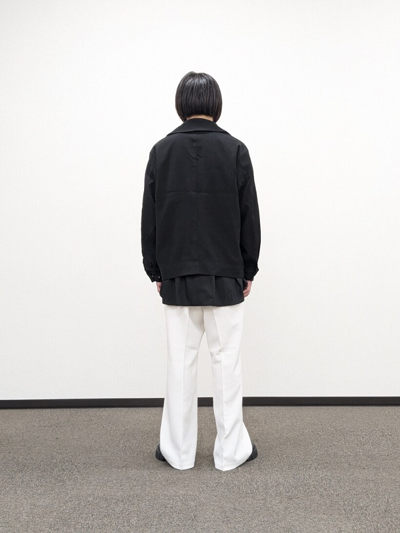 ブラック系のブルゾン、ホワイト系のスラックス、ブラック系のブーツを着用したメンズの秋コーディネートの3枚目の写真