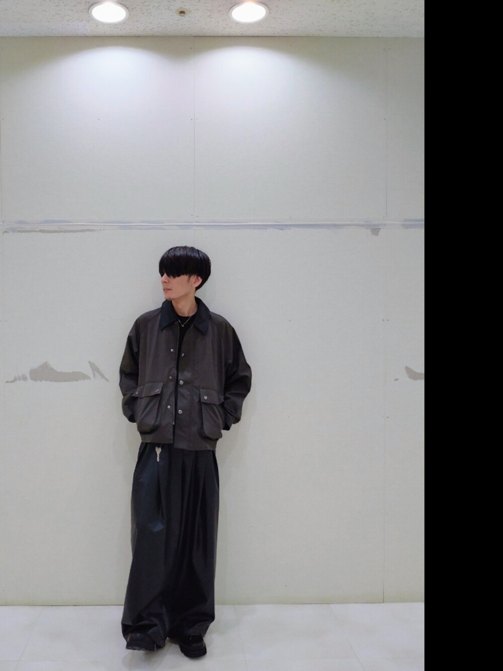 グリーン系のブルゾン、ブラック系のその他パンツ、ブラック系のドレスシューズを着用したメンズの秋コーディネートの4枚目の写真