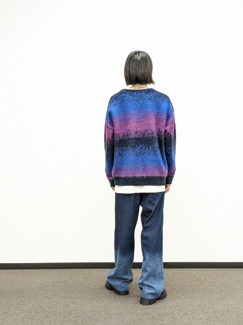 ブルー系のカーディガン/ボレロ、ブルー系のデニムパンツ、ブラック系のブーツを着用したメンズの秋コーディネートの3枚目の写真