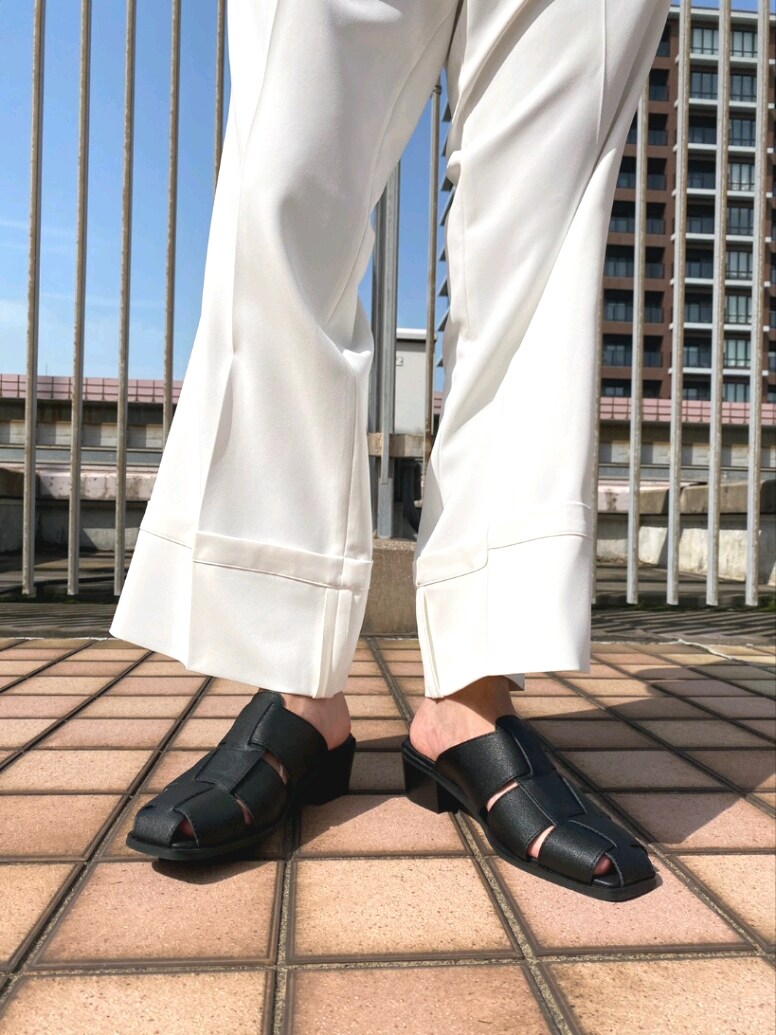 ブラック系のテーラードジャケット、ホワイト系のその他パンツ、ブラック系のサンダルを着用したメンズの春コーディネートの6枚目の写真
