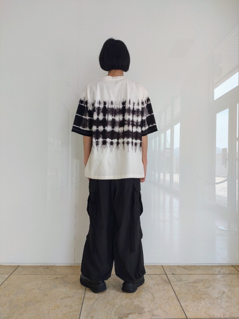 ホワイト系のTシャツ/カットソー、ブラック系のカーゴパンツ、ブラック系のブーツを着用したメンズの春コーディネートの2枚目の写真