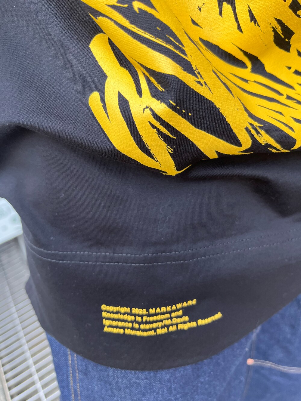 ブルー系のデニムパンツ、ブラック系のTシャツ/カットソー、ブラック系のスニーカーを着用したメンズの春コーディネートの3枚目の写真