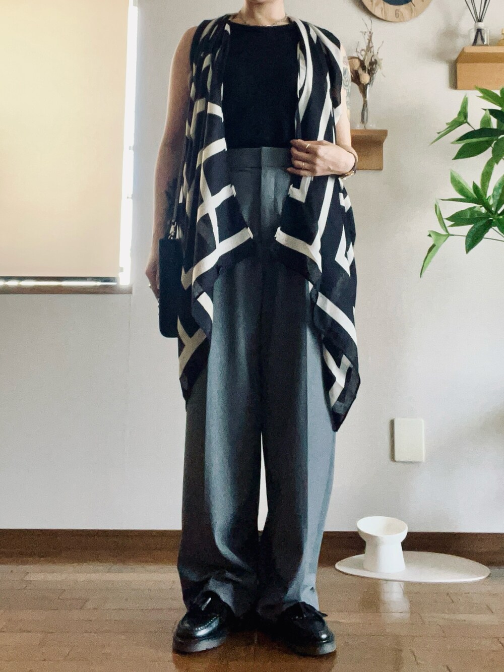 ブラック系のショルダーバッグ、ブラック系のローファー、グレー系のパンツを着用したレディースの秋コーディネートの2枚目の写真