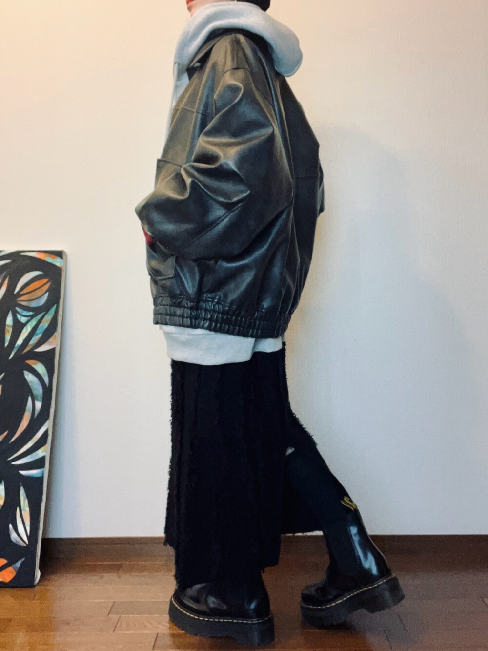 ブラック系のブーツ、ブラック系のスカート、グレー系のパーカーを着用したレディースの冬コーディネートの4枚目の写真