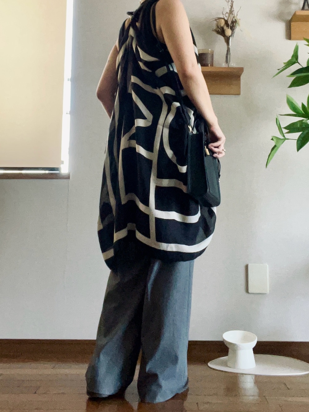 ブラック系のショルダーバッグ、ブラック系のローファー、グレー系のパンツを着用したレディースの秋コーディネートの3枚目の写真