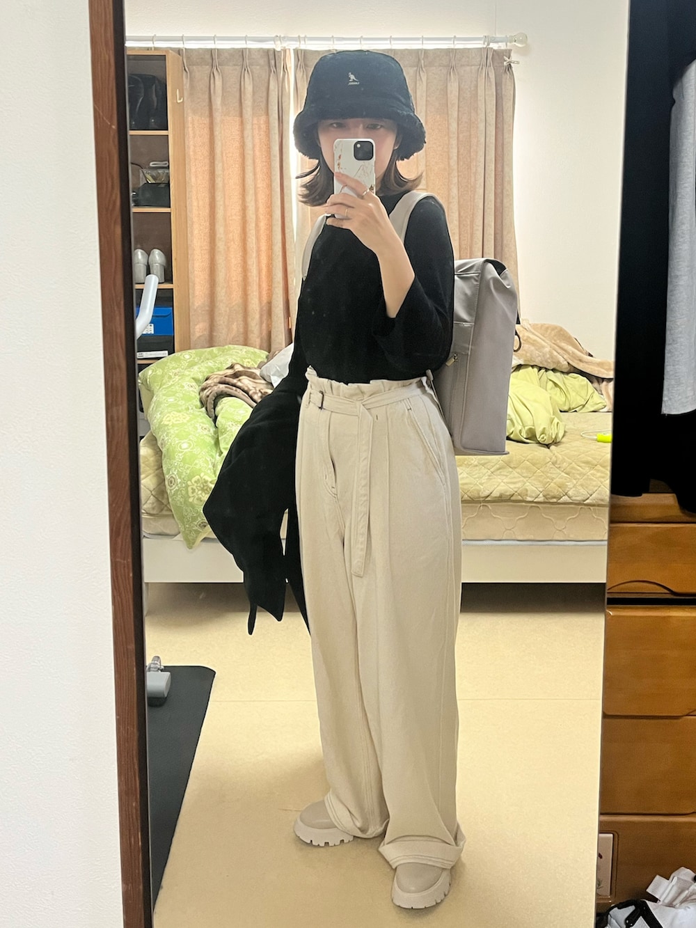 グレー系のバックパック/リュック、ブラック系のジャケット/アウター、ホワイト系のデニムパンツを着用したレディースの秋コーディネートの3枚目の写真