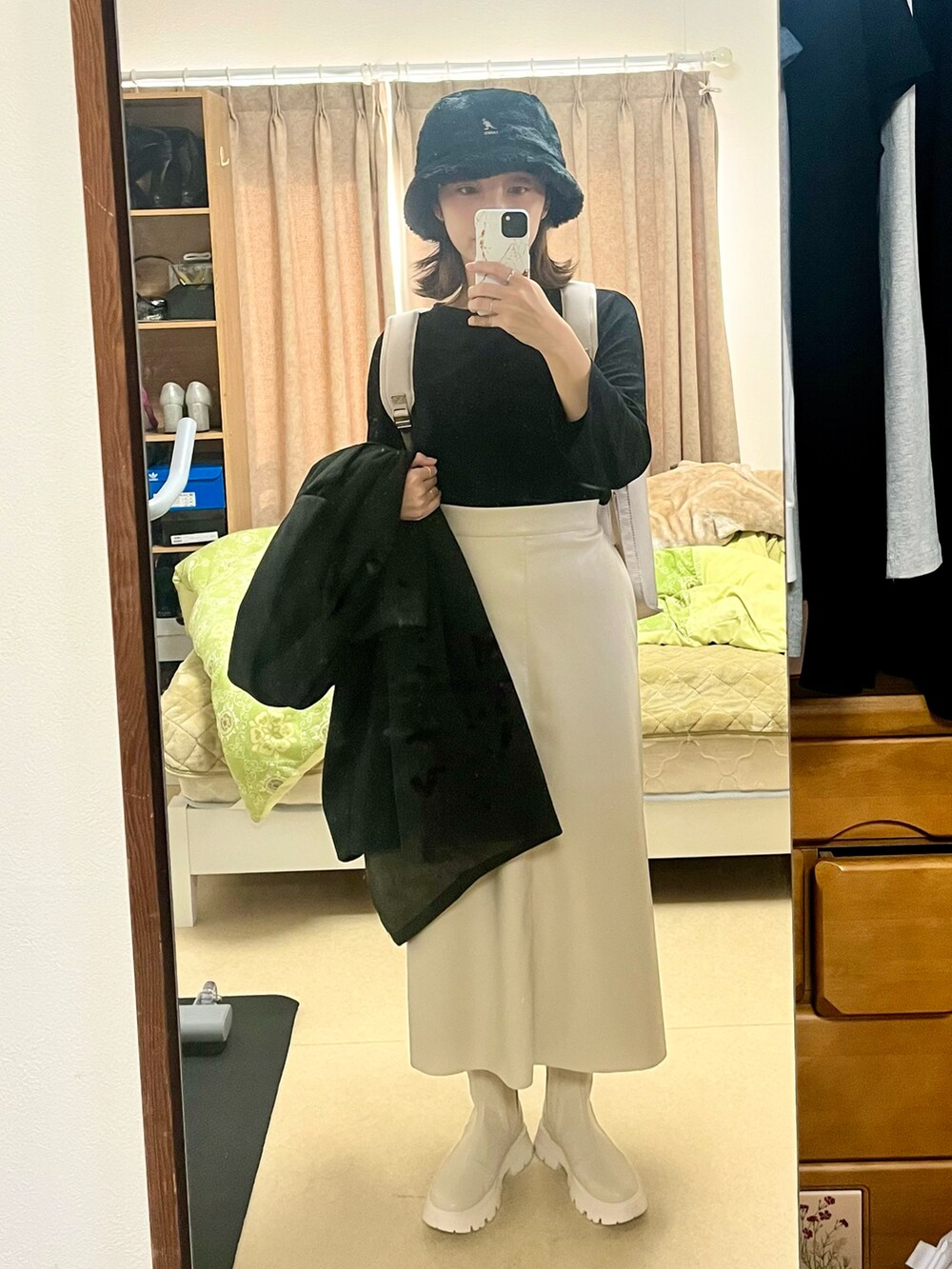 グレー系のバックパック/リュック、ブラック系のジャケット/アウター、ホワイト系のスカートを着用したレディースの秋コーディネートの3枚目の写真