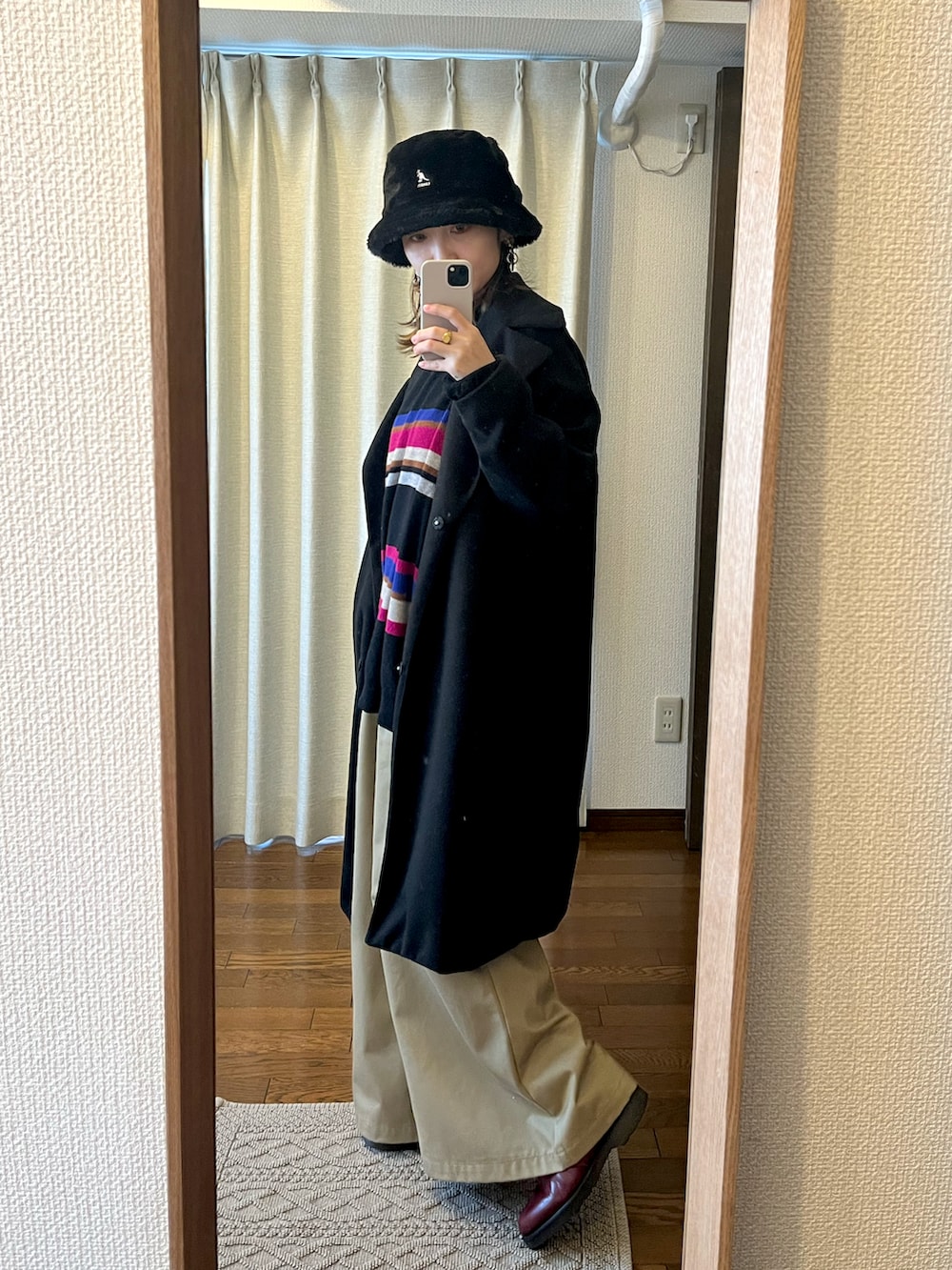 ブラック系のニット/セーター、ブラック系のジャケット/アウター、ベージュ系のパンツを着用したレディースの冬コーディネートの2枚目の写真