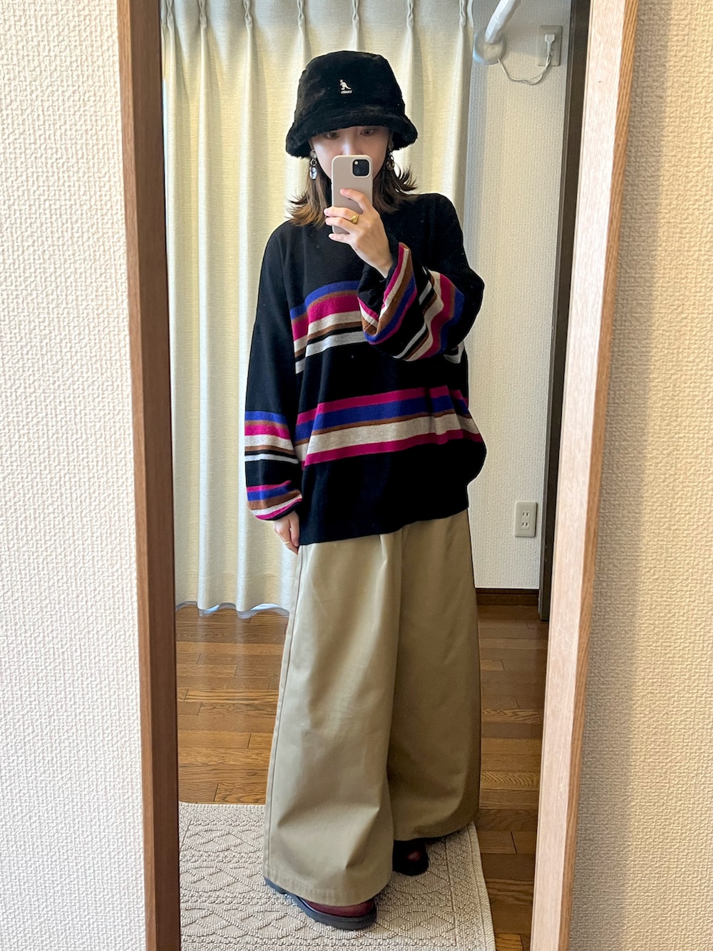 ブラック系のニット/セーター、ブラック系のジャケット/アウター、ベージュ系のパンツを着用したレディースの冬コーディネートの3枚目の写真