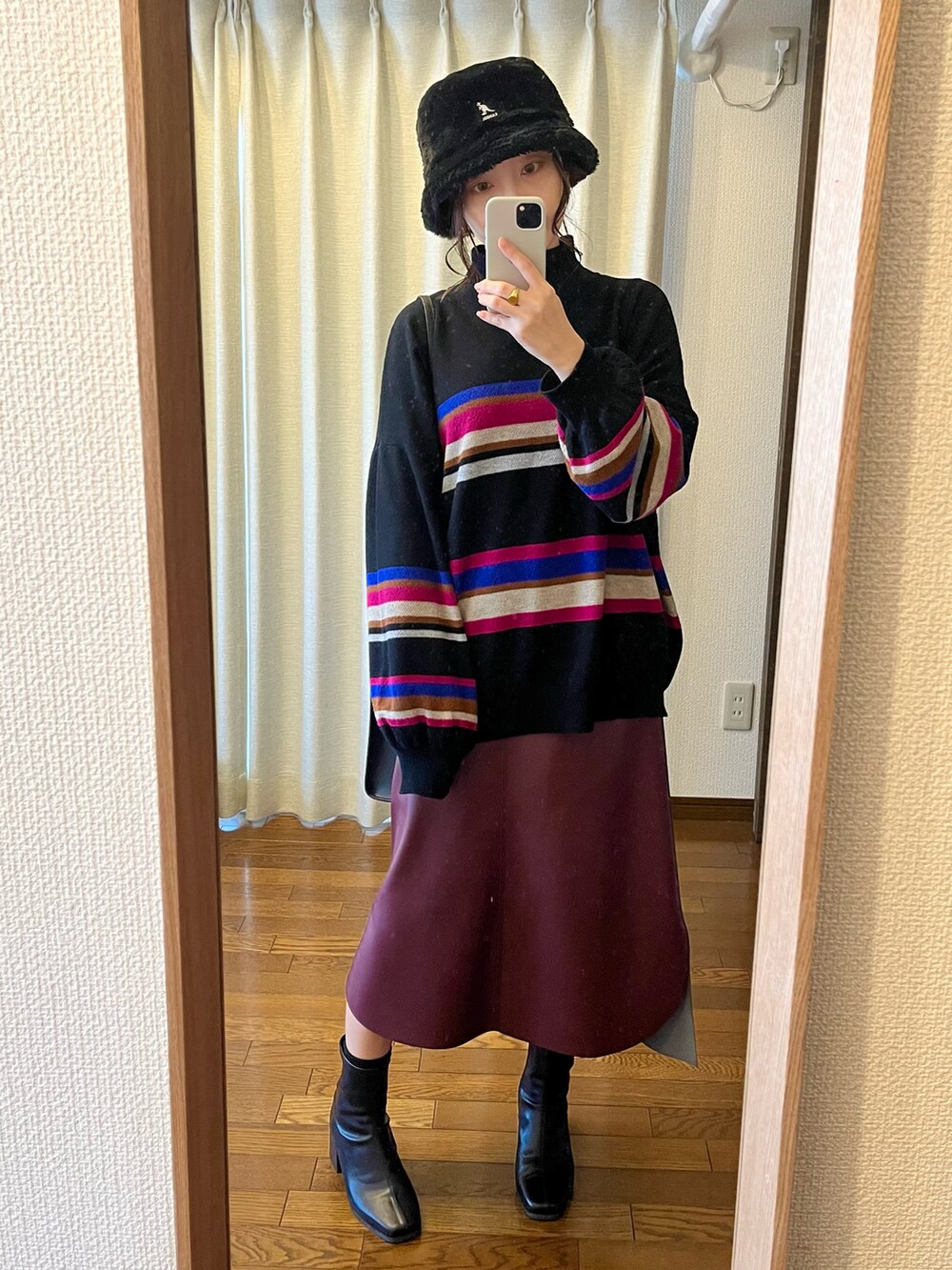 ブラック系のニット/セーター、ブラック系のショルダーバッグ、レッド系のスカートを着用したレディースの春コーディネートの2枚目の写真