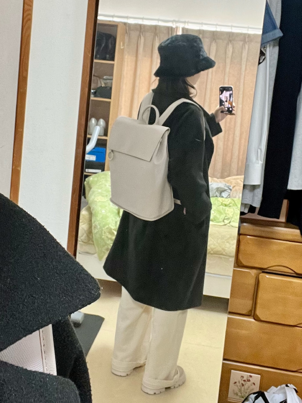 グレー系のバックパック/リュック、ブラック系のジャケット/アウター、ホワイト系のデニムパンツを着用したレディースの秋コーディネートの4枚目の写真