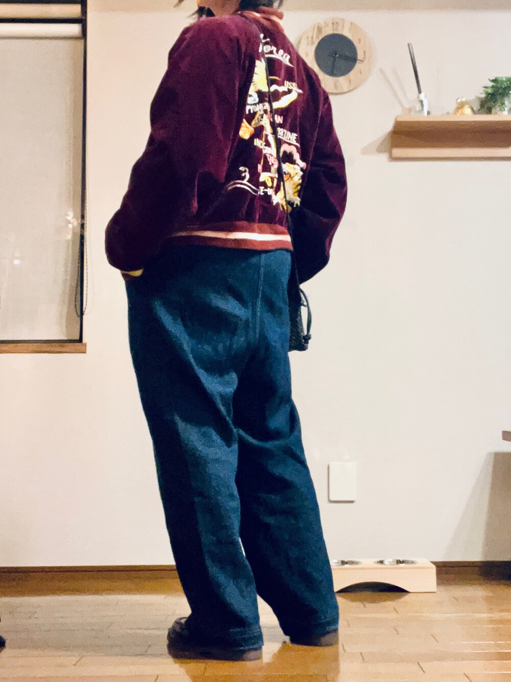 レッド系のスカジャン、ブルー系のデニムパンツ、ブラック系のローファーを着用したレディースの冬コーディネートの2枚目の写真