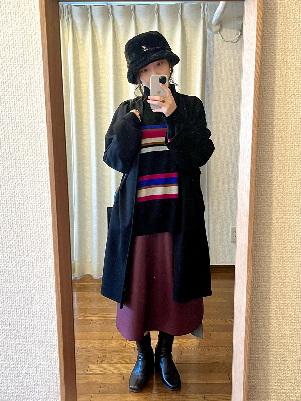 ブラック系のニット/セーター、ブラック系のショルダーバッグ、レッド系のスカートを着用したレディースの春コーディネートの4枚目の写真