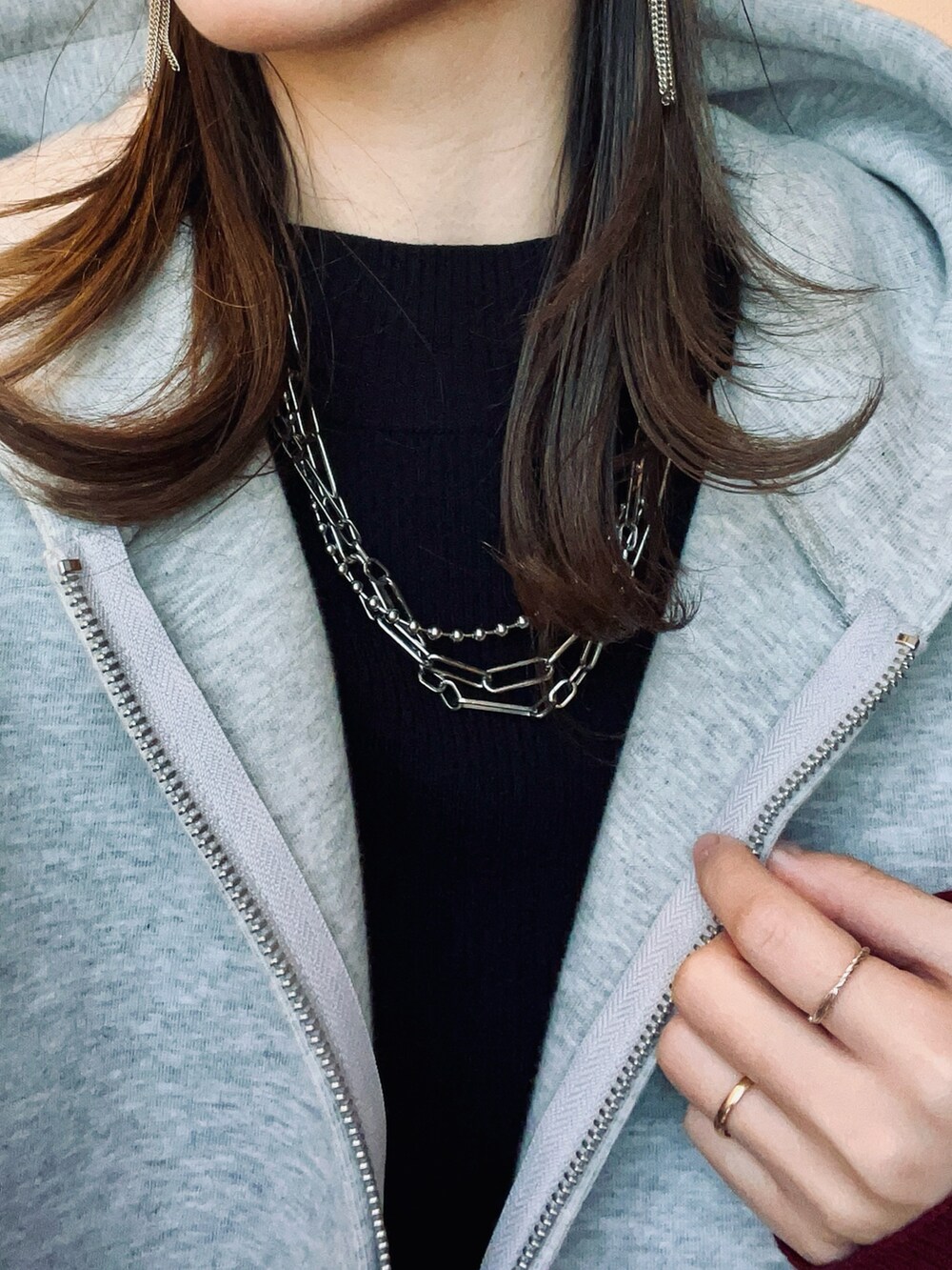 ブラック系のブーツ、ブラック系のスカート、グレー系のパーカーを着用したレディースの冬コーディネートの5枚目の写真