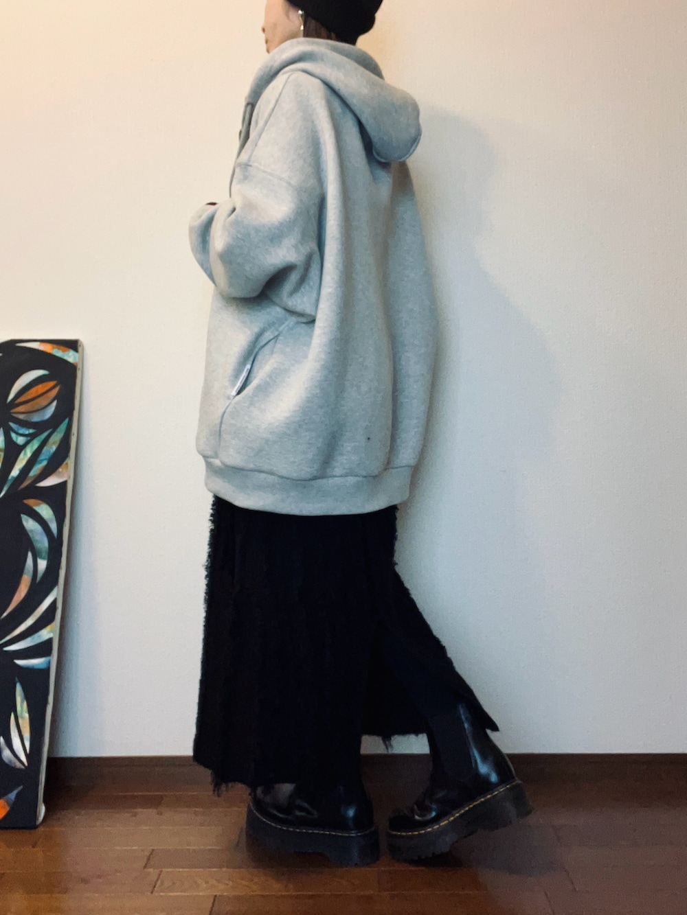 ブラック系のブーツ、ブラック系のスカート、グレー系のパーカーを着用したレディースの冬コーディネートの3枚目の写真