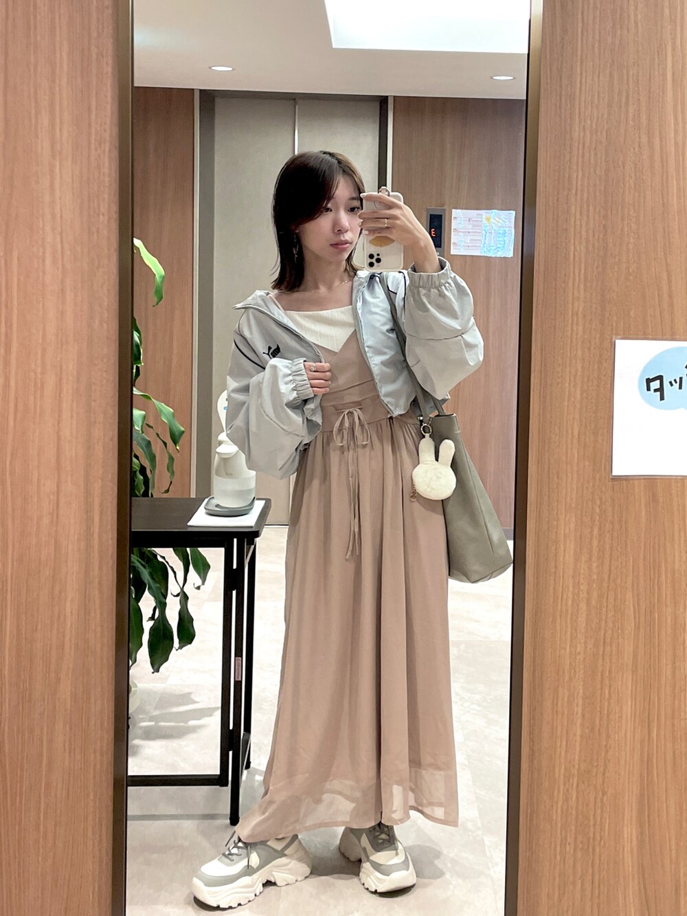 ホワイト系のバッグ、ホワイト系のスニーカー、ブルー系のジャケット/アウターを着用したレディースの秋コーディネートの2枚目の写真