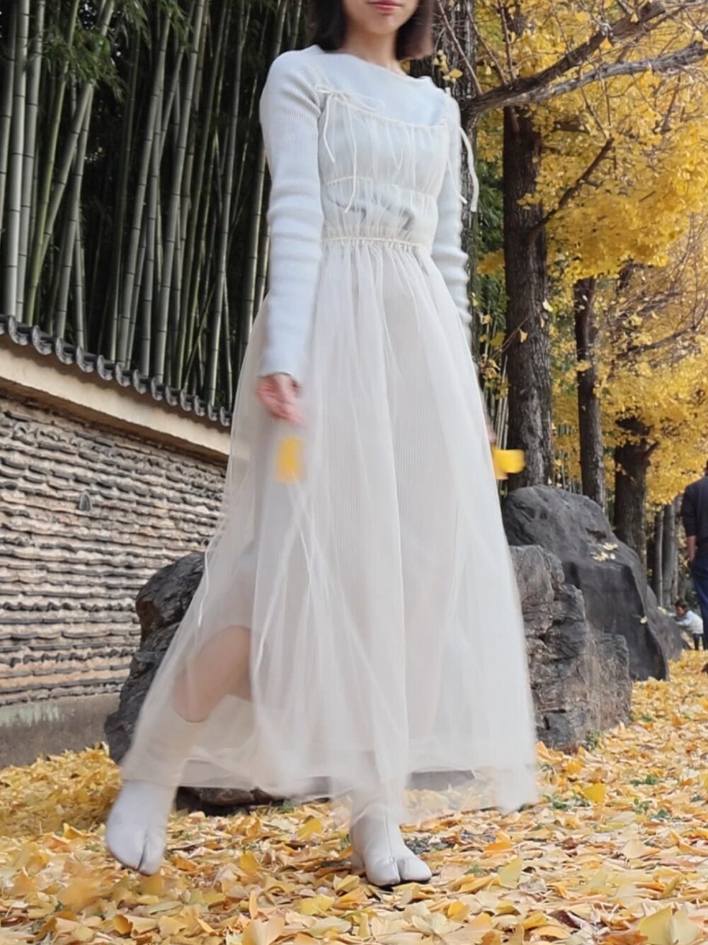 シルバー系のニット/セーター、ホワイト系のワンピース、ブラック系のスカートを着用したレディースの冬コーディネートの2枚目の写真