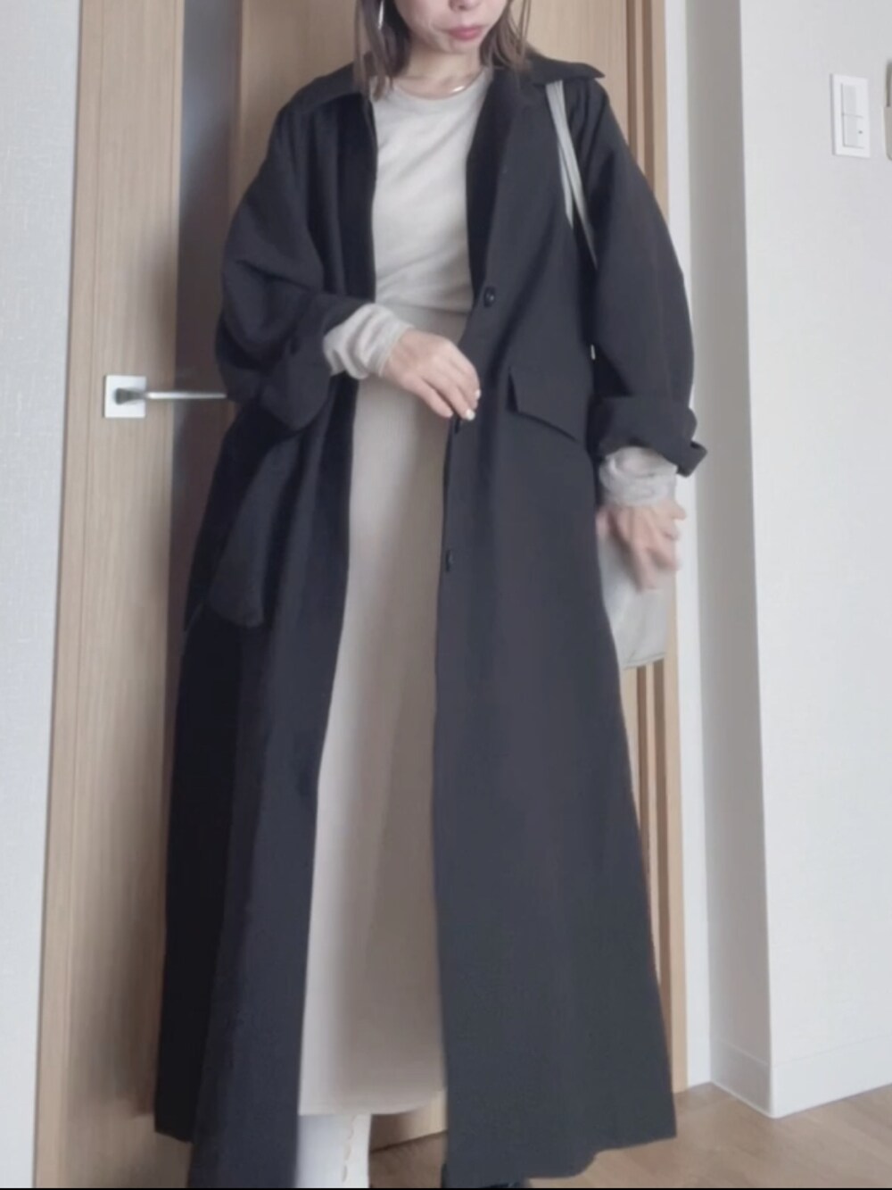 ベージュ系のスカート、ブラック系のダウンジャケット/コート、グレー系のその他トップスを着用したレディースの秋コーディネートの2枚目の写真