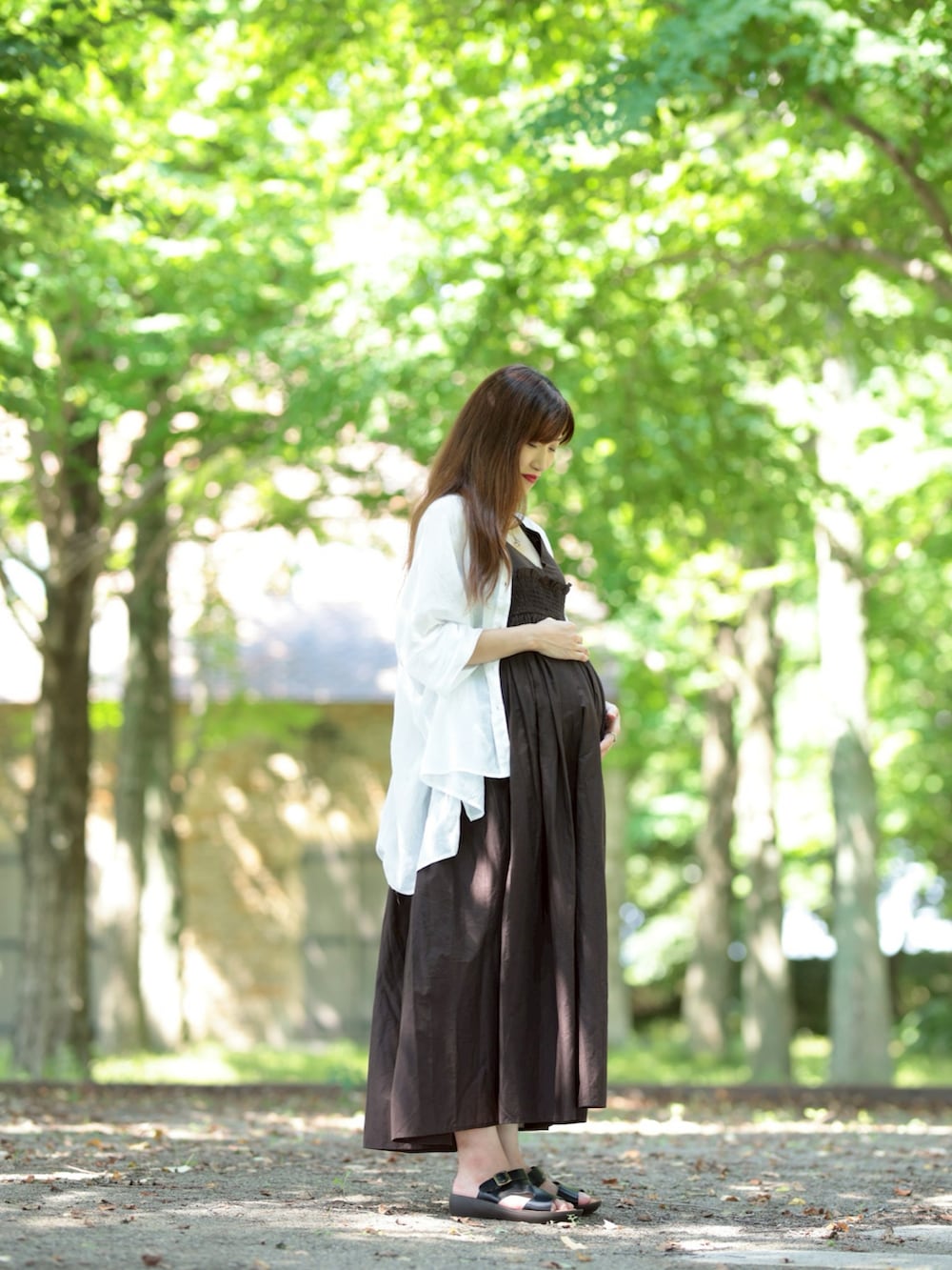 ブラック系のサンダル、ブラウン系のワンピース、ホワイト系のシャツ/ブラウスを着用したレディースの夏コーディネートの2枚目の写真