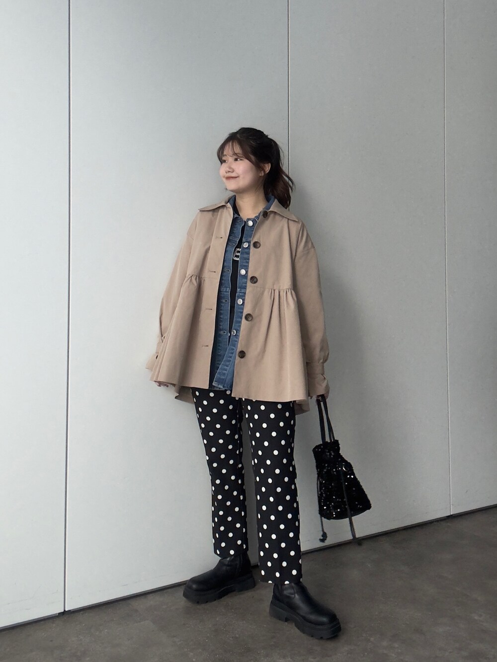 ベージュ系のトレンチコート、ブルー系のデニムジャケット、ブラック系のTシャツ/カットソーを着用したレディースの春コーディネートの2枚目の写真