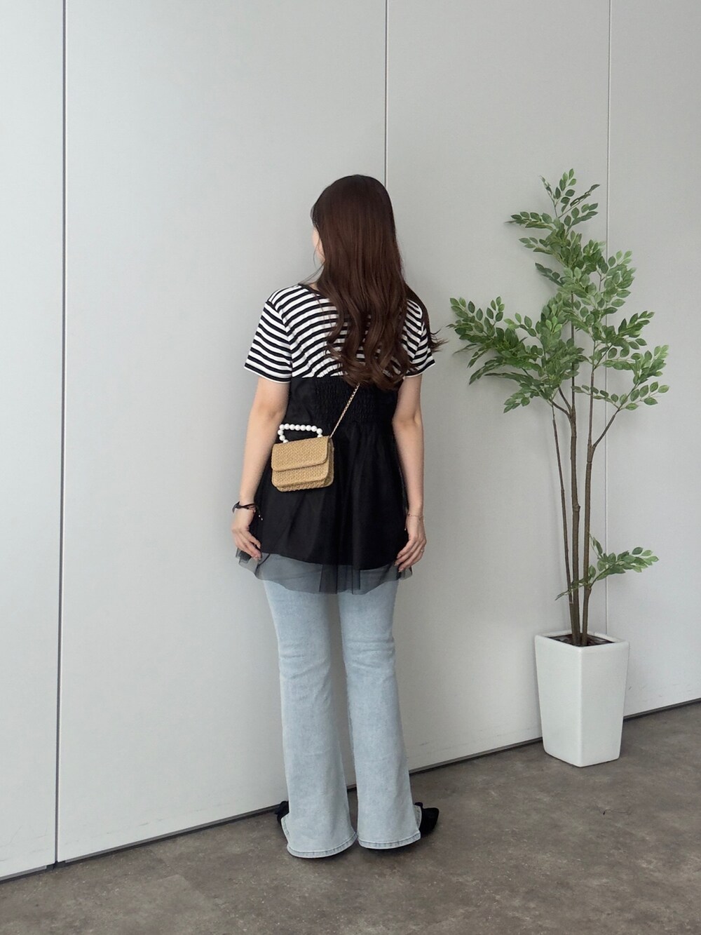 ブラック系のTシャツ/カットソー、ブルー系のデニムパンツ、ブラック系のパンプスを着用したレディースの夏コーディネートの3枚目の写真