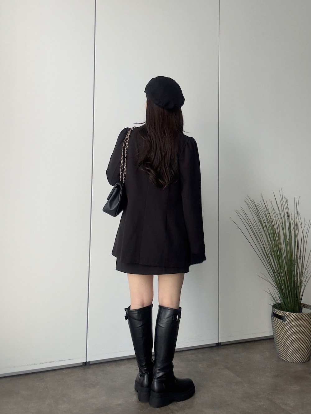 ブラック系のテーラードジャケット、ブラック系のニット/セーター、ブラック系のスカートを着用したレディースの秋コーディネートの3枚目の写真