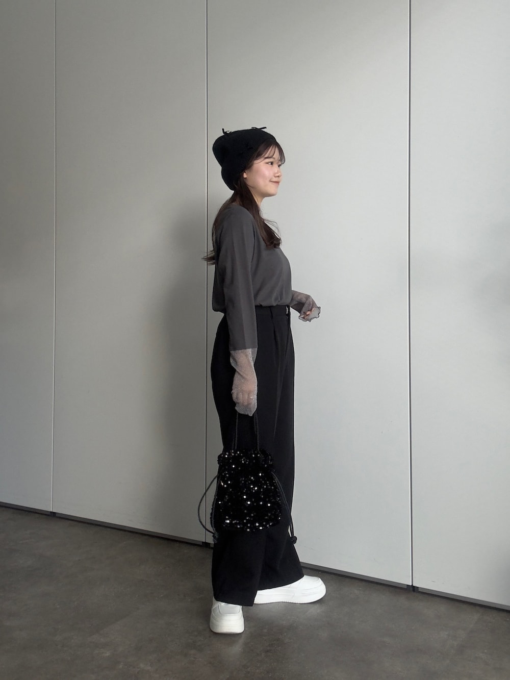 グレー系のTシャツ/カットソー、ブラック系のスラックス、ブラック系のショルダーバッグを着用したレディースの春コーディネートの2枚目の写真