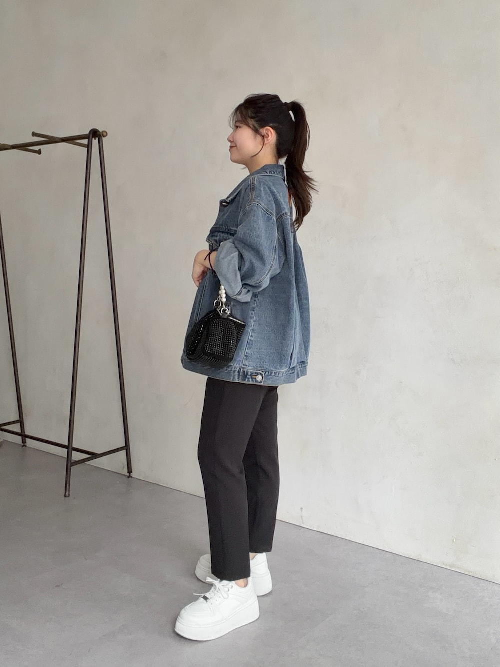 ブルー系のデニムジャケット、ブラック系のその他パンツ、ホワイト系のTシャツ/カットソーを着用したレディースの春コーディネートの2枚目の写真