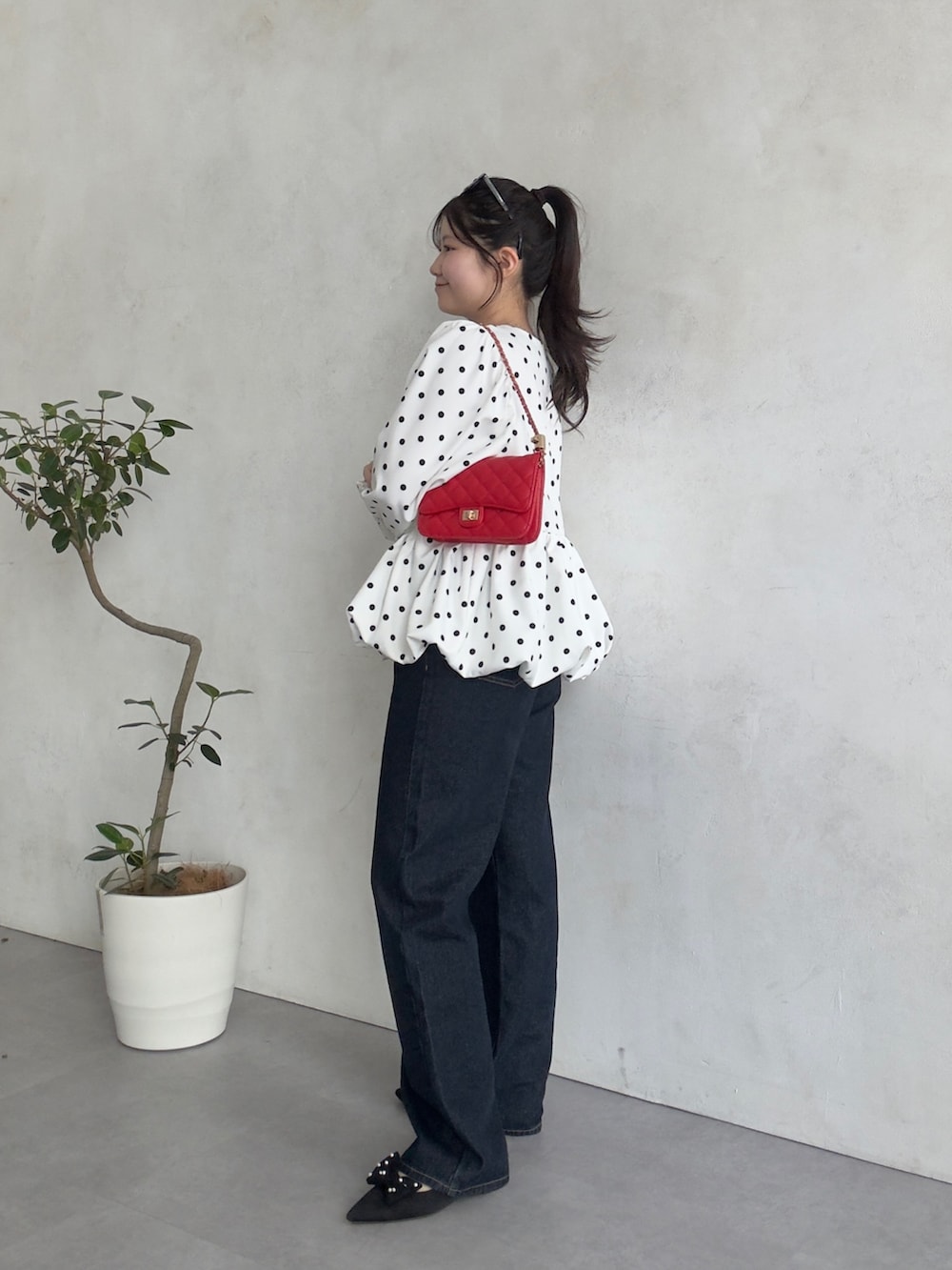 レッド系のトートバッグ、ホワイト系のシャツ/ブラウスを着用したレディースの春コーディネートの2枚目の写真